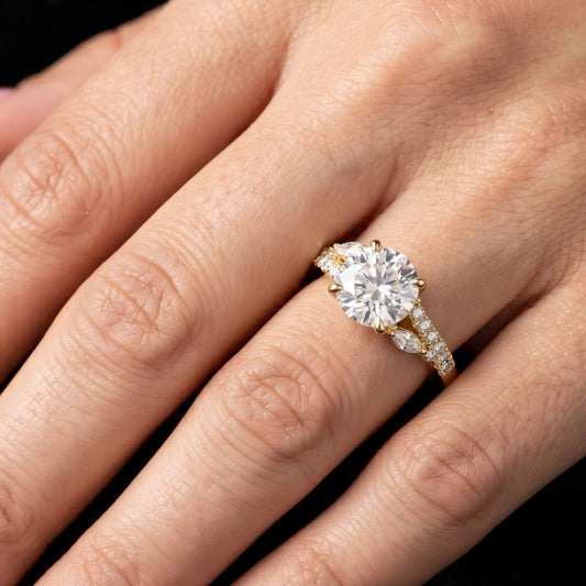 Gold ring with a large moissanite diamond on a hand against a dark background