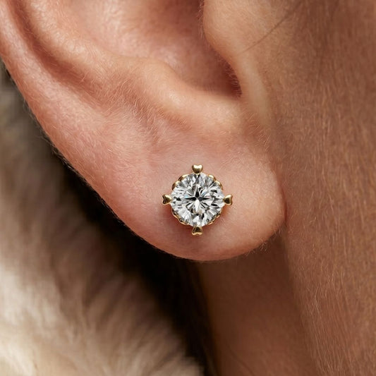 Gold earring with a moissanite diamond on an ear