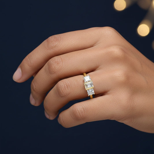 Gold ring with a Moissanite diamond on a hand against a dark background