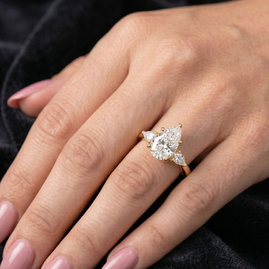 Close-up of a hand wearing a moissanite diamond ring with a black background
