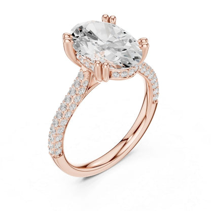 Rose gold ring with a large moissanite diamond and smaller diamonds on the band against a white background