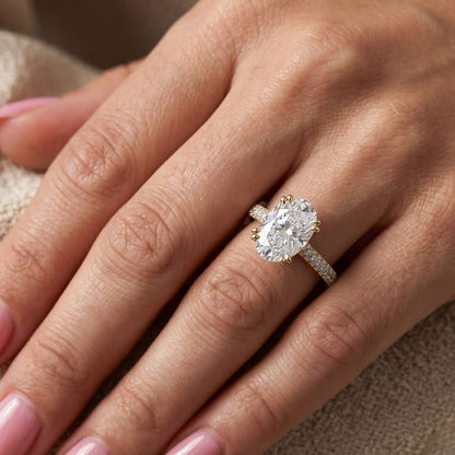 Close-up of a hand wearing a moissanite diamond ring on a neutral background