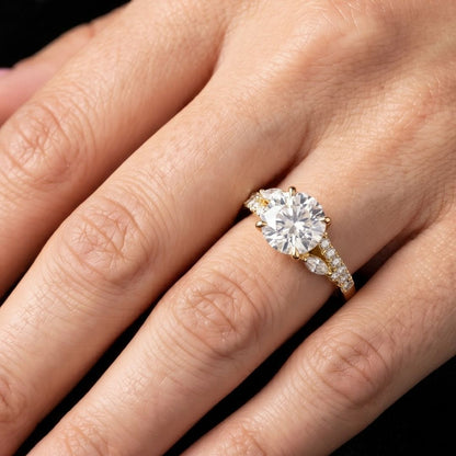 Gold ring with a large moissanite  diamond on a hand against a dark background