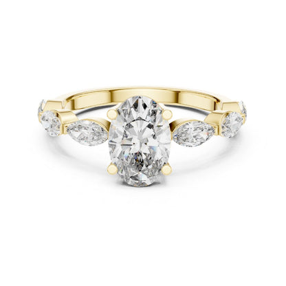 Gold ring with a moissanite central diamond and pear-shaped side stones on a white background