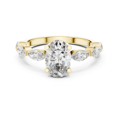 Gold ring with a moissanite central diamond and pear-shaped side stones on a white background