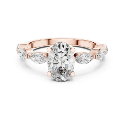 Rose gold ring with a large moissanite diamond and smaller pear-shaped diamonds on a white background