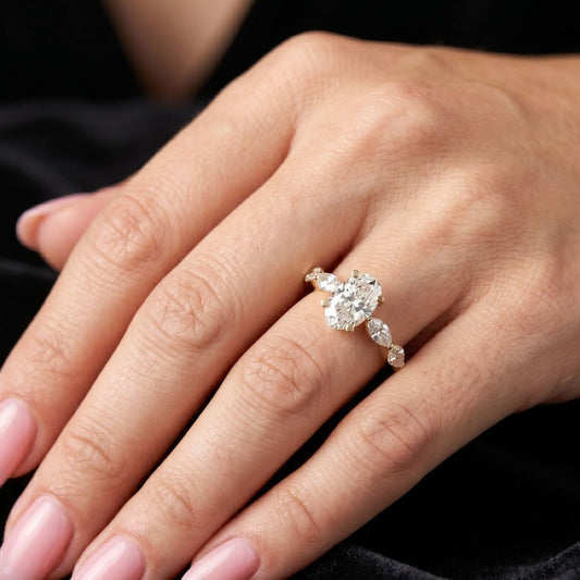Close-up of a hand wearing a moissanite diamond ring with a dark background