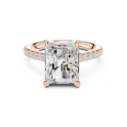 Rose gold ring with a large moissanite  diamond and smaller diamonds on the band against a white background
