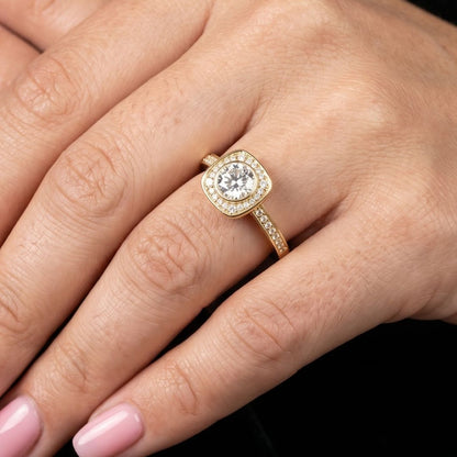 Rose gold ring with a moissanite diamond on a hand against a black background