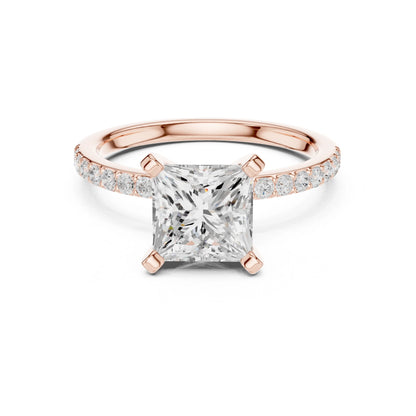 Rose gold ring with a large moissanite diamond and smaller diamonds on the band against a white background