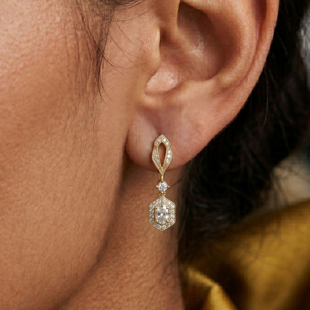 Close-up of a person wearing a gold and diamond earring.