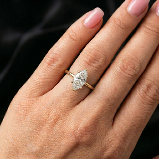 Hand wearing a moissanite diamond ring with a black background