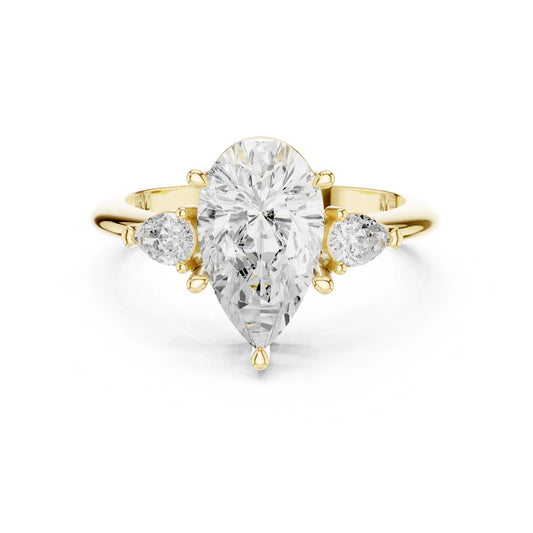 Gold ring with a large pear-shaped moissanite diamond and smaller side stones on a white background