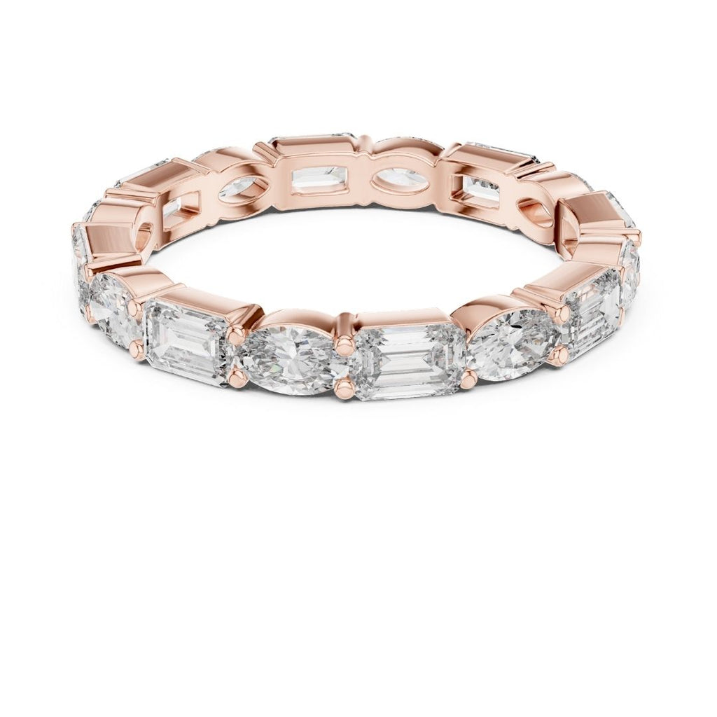 Rose gold ring with emerald-cut moissanite diamonds on a white background