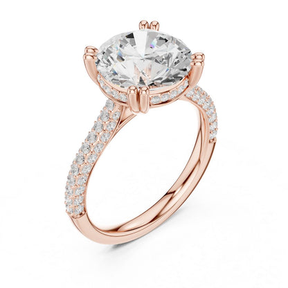 Rose gold ring with a large moissanite diamond and smaller diamonds on the band against a white background