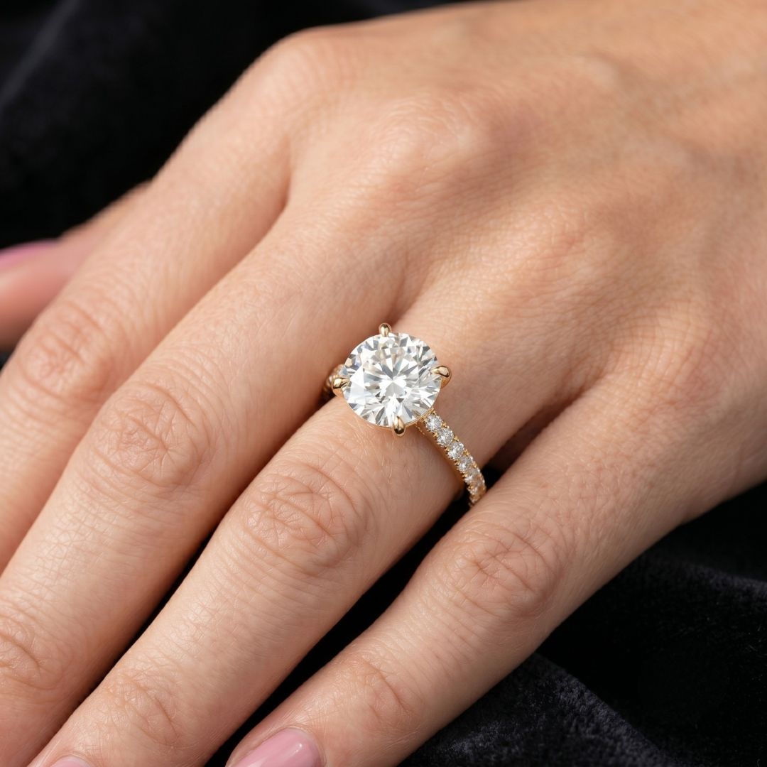 moissanite Diamond ring on a person's finger against a dark background