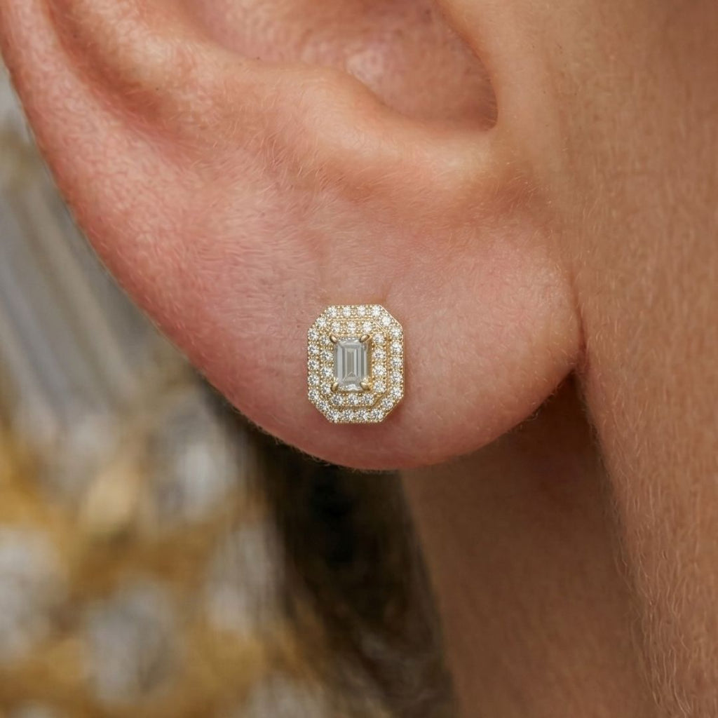 Close-up of a moissanite diamond earring on an ear with a blurred background