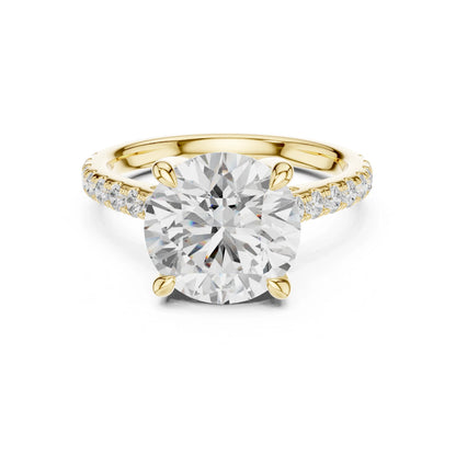 Gold ring with a large moissanite diamond and smaller diamonds on the band against a white background