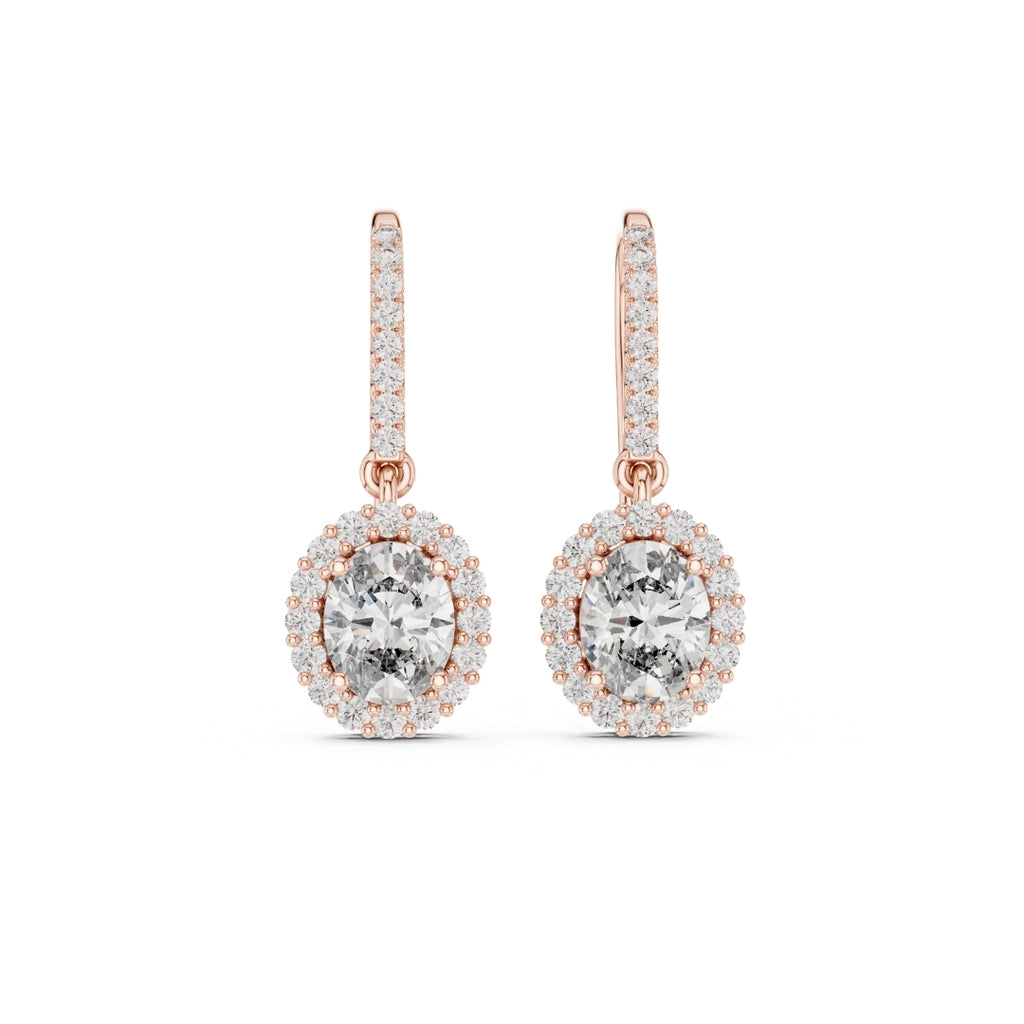 Rose gold earrings with clear moissanite gemstones on a white background