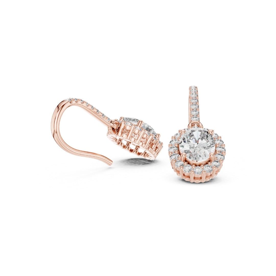 Rose gold earrings with clear moissanite gemstones on a white background