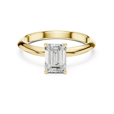 Gold ring with a rectangular moissanite diamond on a white background