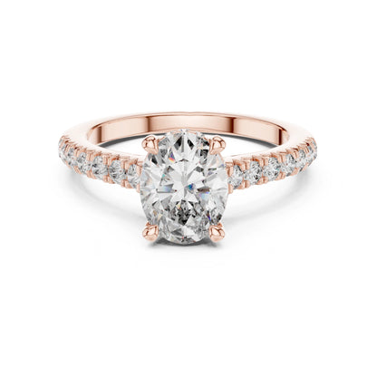 Rose gold ring with a large moissanite  diamond and smaller diamonds on the band against a white background