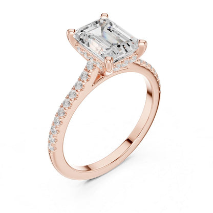 Rose gold ring with a large moissanite  diamond and smaller diamonds on the band against a white background