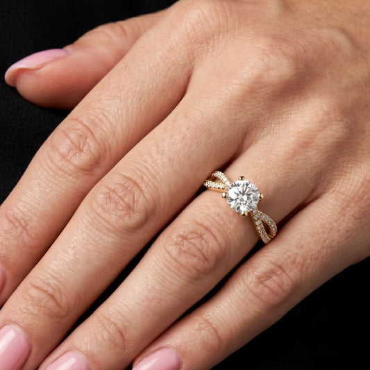 Rose gold ring with a moissanite diamond on a hand against a black background