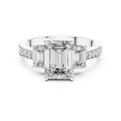 Diamond ring with emerald-cut center moissanite stone and smaller diamonds on a white background