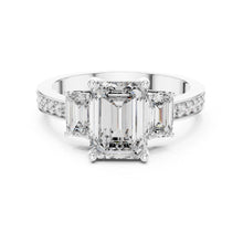 Load image into Gallery viewer, Diamond ring with emerald-cut center moissanite stone and smaller diamonds on a white background