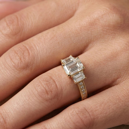 Rose gold ring with emerald-cut moissanite diamonds on a hand