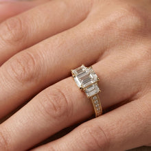 Load image into Gallery viewer, Rose gold ring with emerald-cut moissanite diamonds on a hand