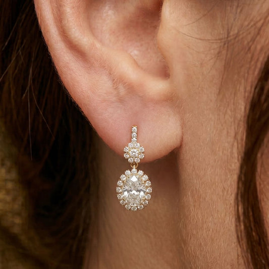 Close-up of an ear wearing a moissanite diamond earring with a blurred background