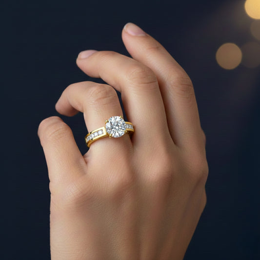 Gold ring with a moissanite diamond on a hand against a dark background
