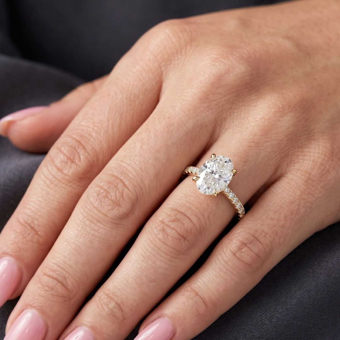 Rose gold ring with a large moissanite diamond on a hand against a dark background