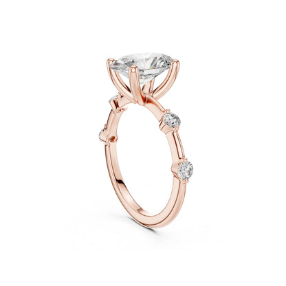 Rose gold ring with a 2CT MOISSANITE central diamond and smaller side diamonds on a white background