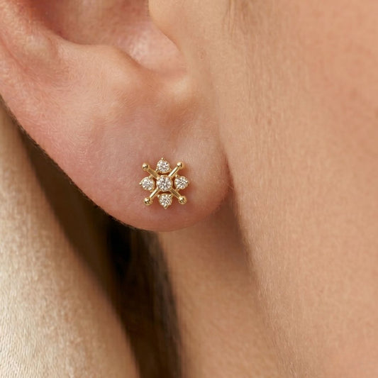 Gold earring with small moissanite diamonds on a person's ear