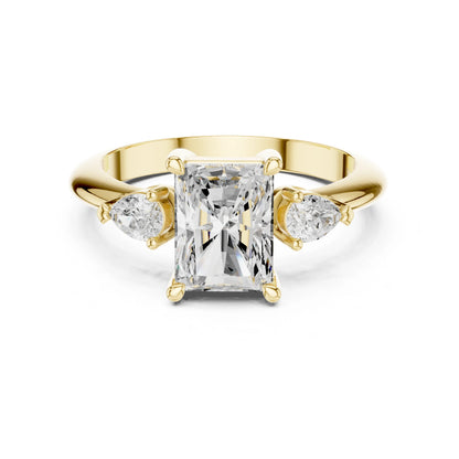 Gold ring with a central moissanite diamond and two smaller diamonds on a white background