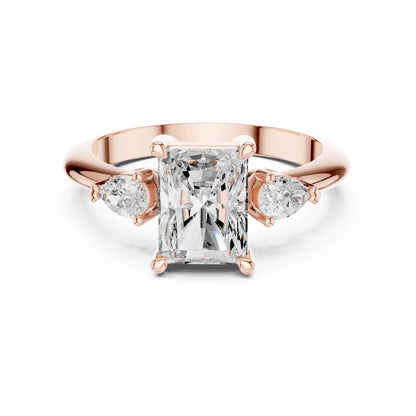 Rose gold ring with a large moissanite diamond and smaller side stones on a white background