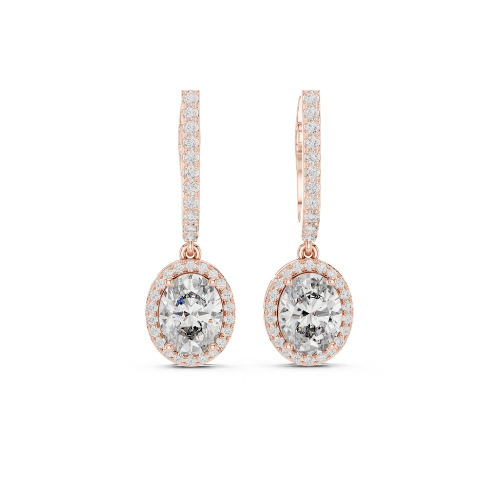 Rose gold earrings with clear moissanite gemstones on a white background