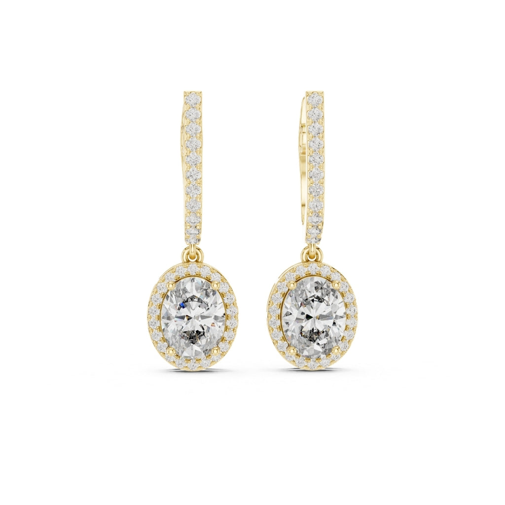 Gold earrings with clear gemstones on a white background