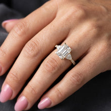 Load image into Gallery viewer, Close-up of a hand wearing a moissanite diamond ring with a dark background