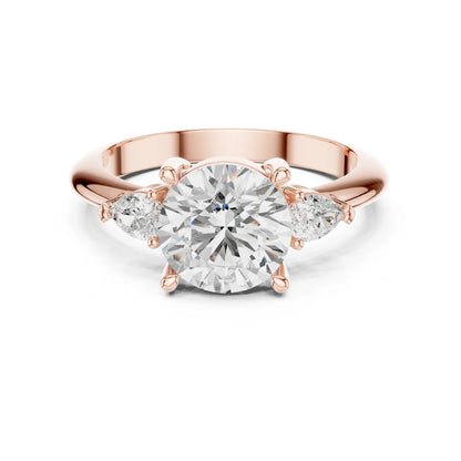 Rose gold ring with a large moissanite diamond and smaller side stones on a white background