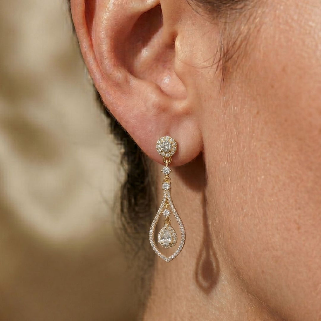 Close-up of a woman's ear wearing a moissanite diamond earring with a blurred background