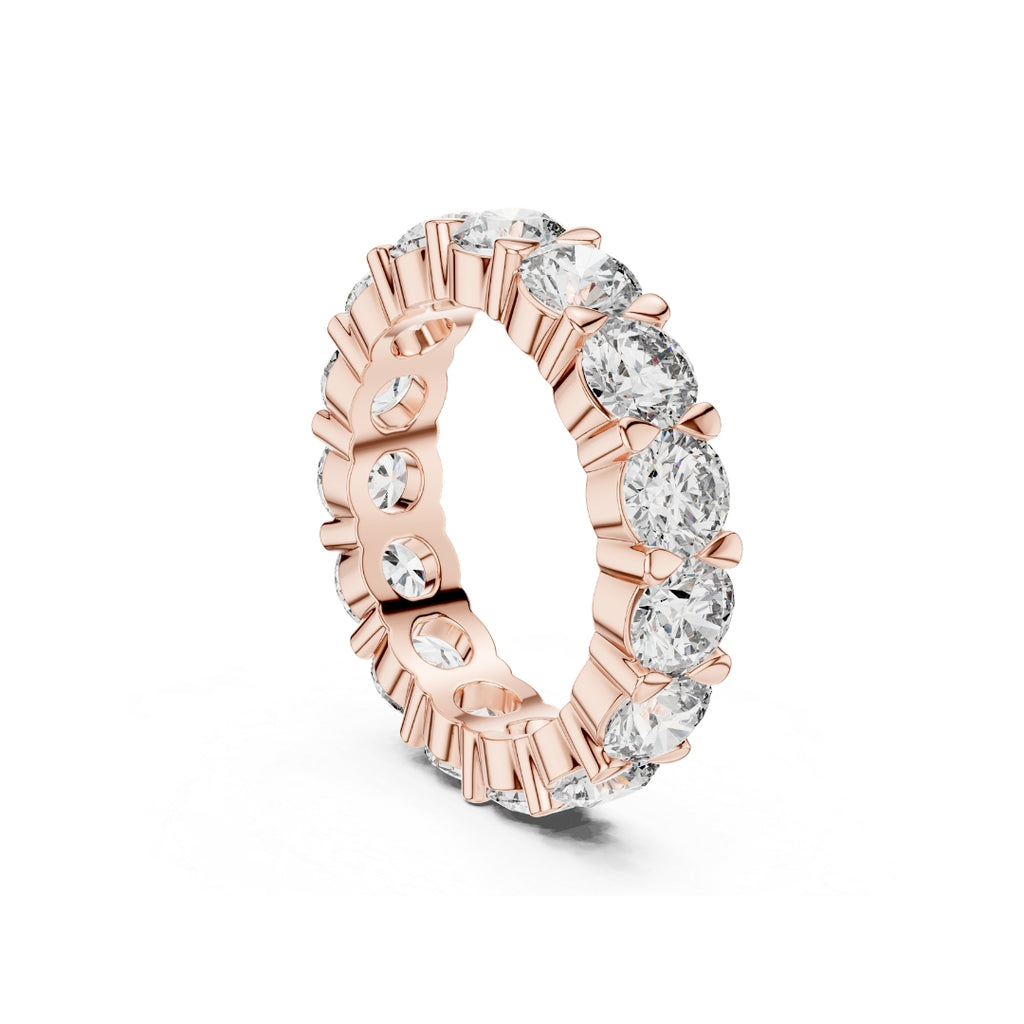 Rose gold ring with clear Moissanite gemstones on a white background