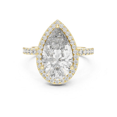 Gold ring with a large pear-shaped moissanite diamond and smaller diamonds on a white background