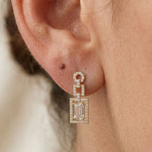 Load image into Gallery viewer, Close-up of an ear wearing a moissanite diamond earring with a blurred background