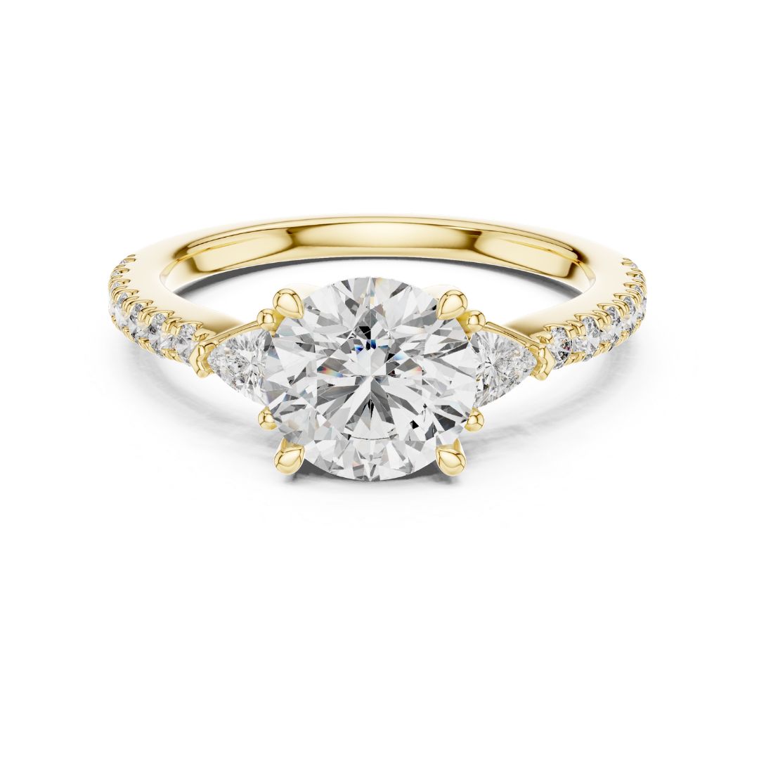 Gold ring with a large moissanite diamond and smaller diamonds on the band against a white background