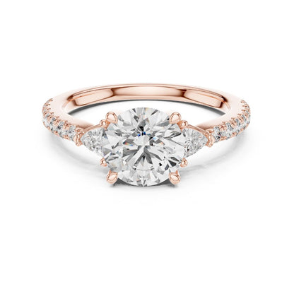 Rose gold ring with a large moissanite diamond and smaller diamonds on the band against a white background