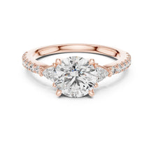 Load image into Gallery viewer, Rose gold ring with a large moissanite diamond and smaller diamonds on the band against a white background